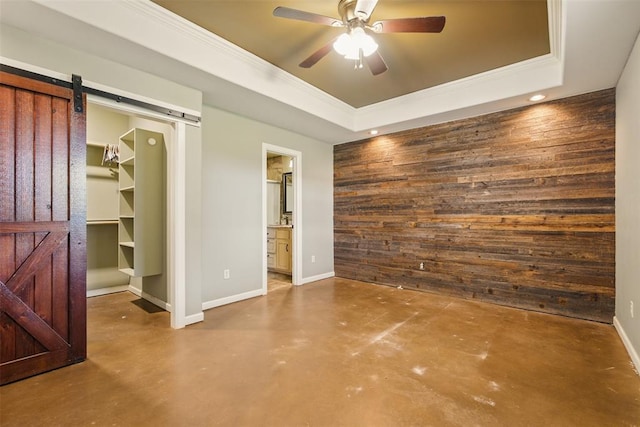 5801 N Henney Rd, Coyle, OK 73027 - unfurnished bedroom with a barn door, finished concrete flooring, wood walls, a tray ceiling, and ornamental molding