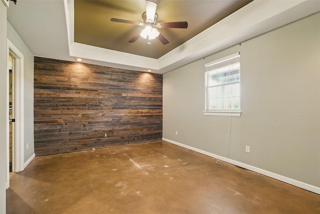 5801 N Henney Rd, Coyle, OK 73027 - empty room with wooden walls, finished concrete flooring, a raised ceiling, ceiling fan, and an accent wall
