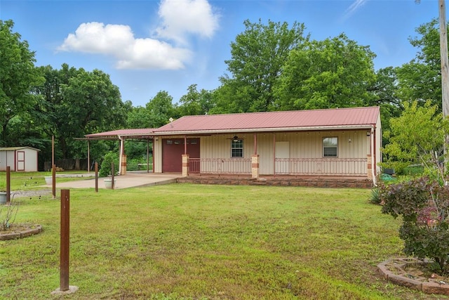 5801 N Henney Rd, Coyle, OK 73027 - view of front of home with covered porch, a storage shed, a front yard, a metal roof, and board and batten siding