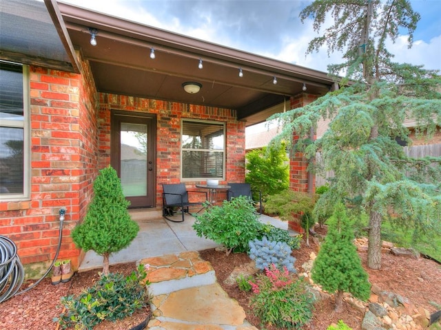 10705 SW 36th St, Yukon, OK 73099 - doorway to property featuring brick siding and a porch