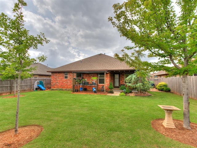 10705 SW 36th St, Yukon, OK 73099 - back of property with a shingled roof, a fenced backyard, and brick siding