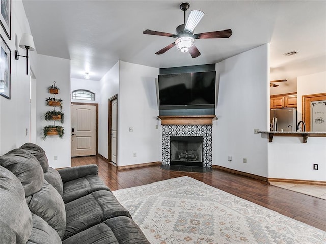 10705 SW 36th St, Yukon, OK 73099 - living area featuring a ceiling fan, hardwood / wood-style floors, and a tiled fireplace