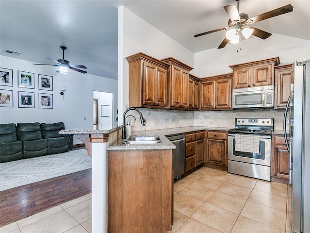 10705 SW 36th St, Yukon, OK 73099 - kitchen with appliances with stainless steel finishes, a ceiling fan, light tile patterned floors, and brown cabinetry