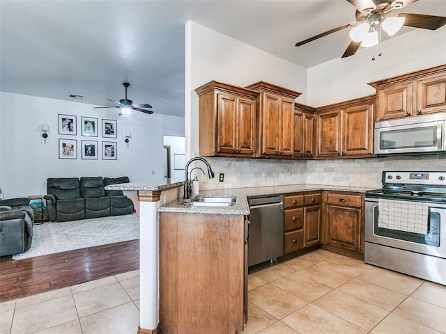 10705 SW 36th St, Yukon, OK 73099 - kitchen featuring stainless steel appliances, a ceiling fan, open floor plan, light tile patterned floors, and backsplash
