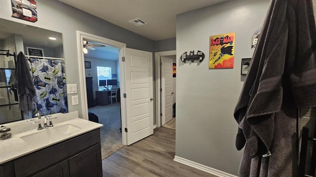 11704 SW 40th St, Mustang, OK 73064 - bathroom with vanity, wood finished floors, ceiling fan, and a shower with shower curtain