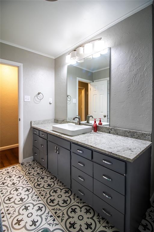1712 N Pennsylvania Ave, Shawnee, OK 74804 - bathroom with crown molding, vanity, a textured wall, and tile patterned flooring