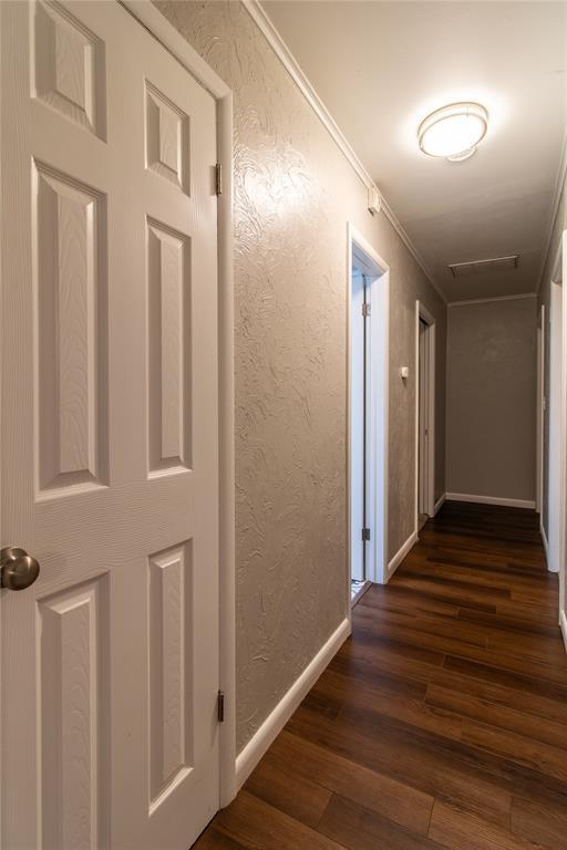 1712 N Pennsylvania Ave, Shawnee, OK 74804 - corridor with dark wood-style flooring, a textured wall, and ornamental molding