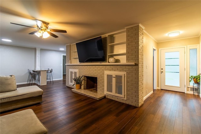 1712 N Pennsylvania Ave, Shawnee, OK 74804 - living area featuring a ceiling fan, a brick fireplace, dark wood-style flooring, ornamental molding, and recessed lighting