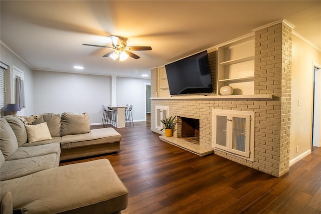 1712 N Pennsylvania Ave, Shawnee, OK 74804 - living room featuring ornamental molding, ceiling fan, dark wood-style flooring, a brick fireplace, and recessed lighting