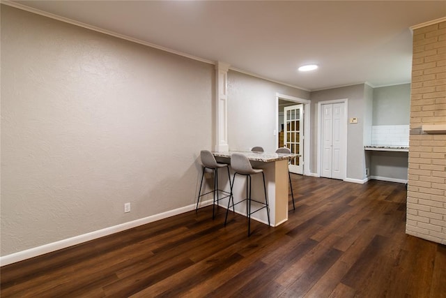 1712 N Pennsylvania Ave, Shawnee, OK 74804 - kitchen featuring dark wood-style floors, light stone counters, a kitchen breakfast bar, crown molding, and recessed lighting