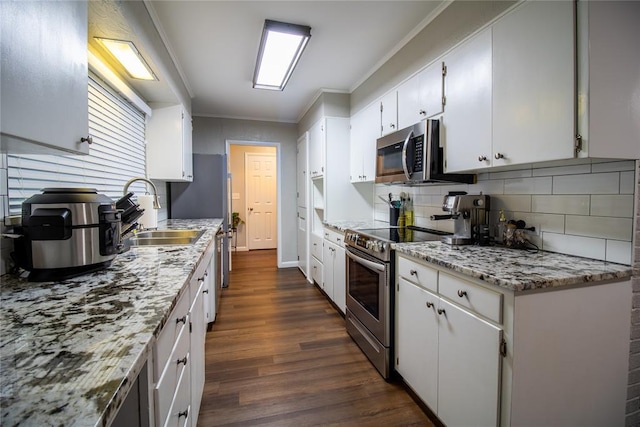 1712 N Pennsylvania Ave, Shawnee, OK 74804 - kitchen featuring stainless steel appliances, tasteful backsplash, crown molding, dark wood-type flooring, and white cabinets