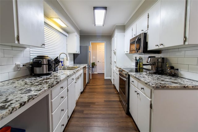 1712 N Pennsylvania Ave, Shawnee, OK 74804 - kitchen featuring appliances with stainless steel finishes, tasteful backsplash, white cabinetry, dark wood-style floors, and crown molding