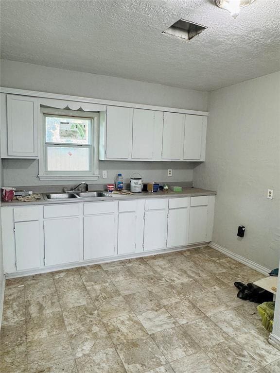 104 S Ross St, Walters, OK 73572 - kitchen with white cabinetry, light countertops, and a textured ceiling