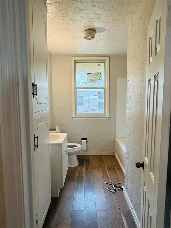104 S Ross St, Walters, OK 73572 - full bath featuring wood-type flooring, vanity, a textured ceiling, and a textured wall