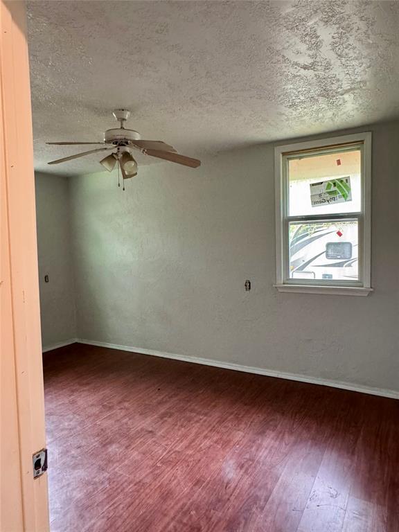 104 S Ross St, Walters, OK 73572 - spare room featuring wood finished floors, a textured ceiling, and ceiling fan