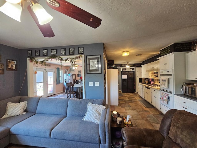 3205 NW 62nd St, Oklahoma City, OK 73112 - living room with stone finish floors, ceiling fan, and a textured ceiling