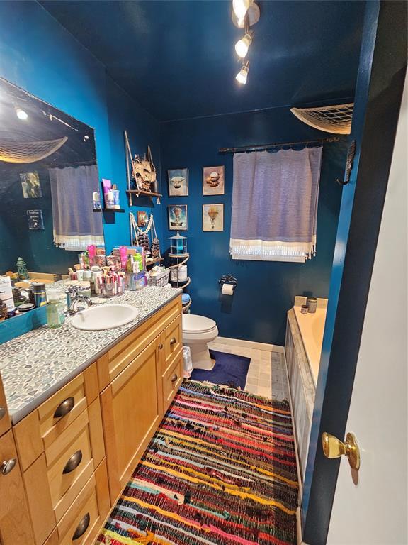 3205 NW 62nd St, Oklahoma City, OK 73112 - bathroom featuring vanity, a tub to relax in, and tile patterned floors
