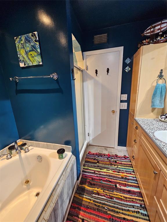 3205 NW 62nd St, Oklahoma City, OK 73112 - bathroom featuring vanity, a shower stall, a bath, and tile patterned floors