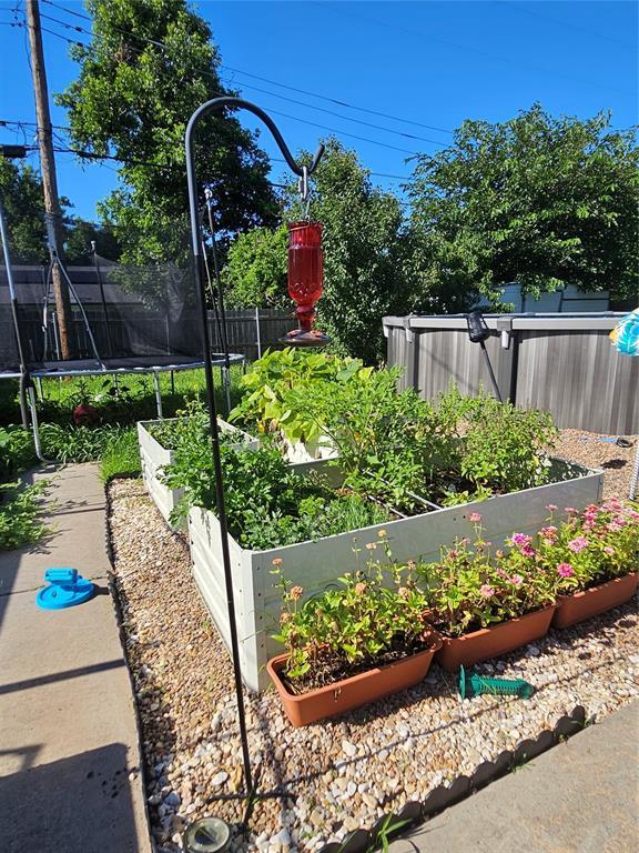 3205 NW 62nd St, Oklahoma City, OK 73112 - view of yard featuring a vegetable garden and a trampoline