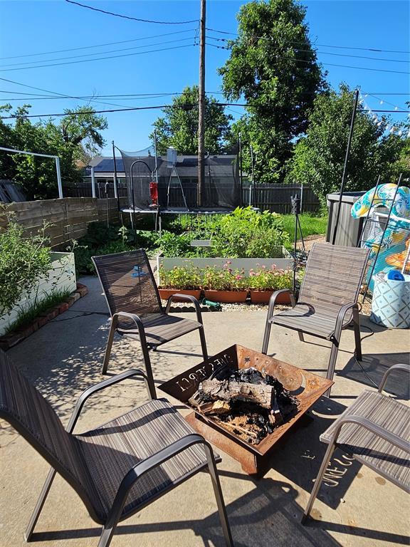 3205 NW 62nd St, Oklahoma City, OK 73112 - fenced backyard with a trampoline, a patio, and an outdoor fire pit