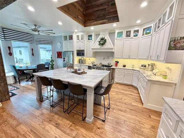 1118 Fernwood Dr, Midwest City, OK 73130 - kitchen with custom exhaust hood, stainless steel appliances, recessed lighting, light wood-style floors, and tasteful backsplash