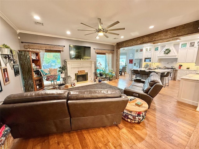 1118 Fernwood Dr, Midwest City, OK 73130 - living room with ceiling fan, ornamental molding, light wood-style floors, recessed lighting, and a high end fireplace