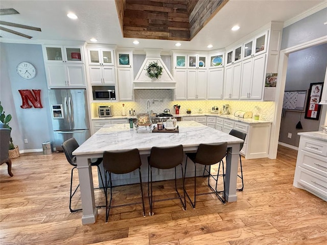 1118 Fernwood Dr, Midwest City, OK 73130 - kitchen with appliances with stainless steel finishes, premium range hood, a breakfast bar, tasteful backsplash, and recessed lighting