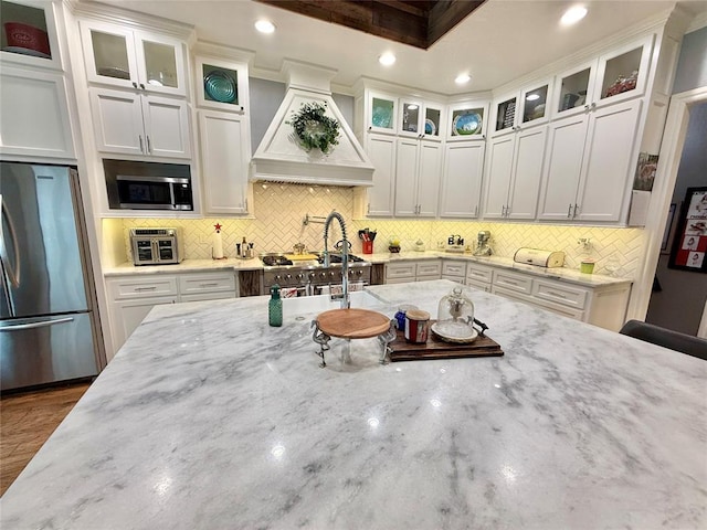1118 Fernwood Dr, Midwest City, OK 73130 - kitchen featuring stainless steel appliances, custom range hood, white cabinets, decorative backsplash, and recessed lighting