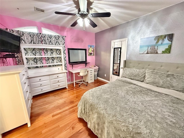 1118 Fernwood Dr, Midwest City, OK 73130 - bedroom with light wood-type flooring, a textured wall, and ceiling fan