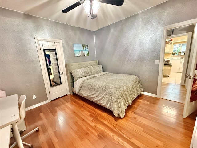 1118 Fernwood Dr, Midwest City, OK 73130 - bedroom with a textured wall, light wood finished floors, ceiling fan, and washer / clothes dryer