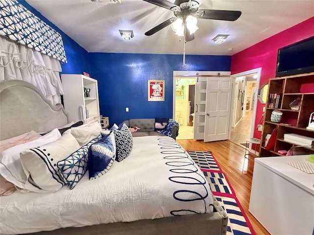 1118 Fernwood Dr, Midwest City, OK 73130 - bedroom with wood finished floors, ceiling fan, and fridge