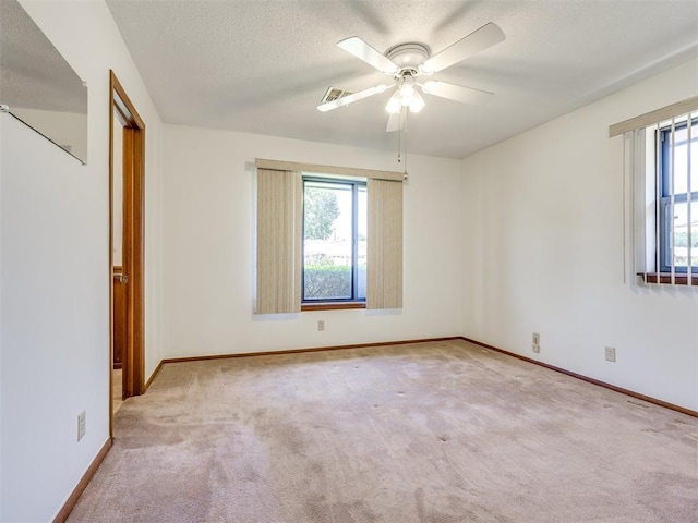 7600 NW 27th St, Bethany, OK 73008 - unfurnished bedroom with carpet floors, multiple windows, a textured ceiling, and ceiling fan