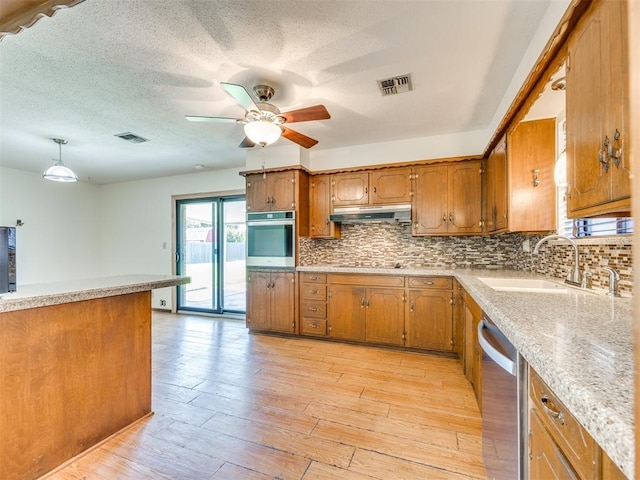 7600 NW 27th St, Bethany, OK 73008 - kitchen with stainless steel appliances, brown cabinetry, a ceiling fan, and light countertops