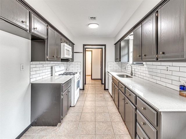 535 N Patchin Ave, Shawnee, OK 74801 - kitchen featuring white appliances, decorative backsplash, light countertops, and light tile patterned flooring