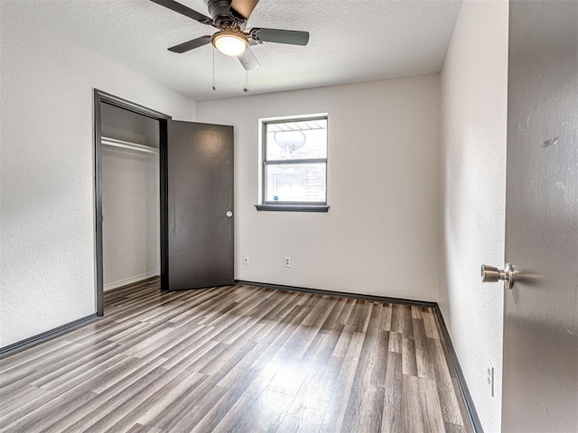 535 N Patchin Ave, Shawnee, OK 74801 - unfurnished bedroom with wood finished floors, a closet, ceiling fan, a textured ceiling, and a textured wall