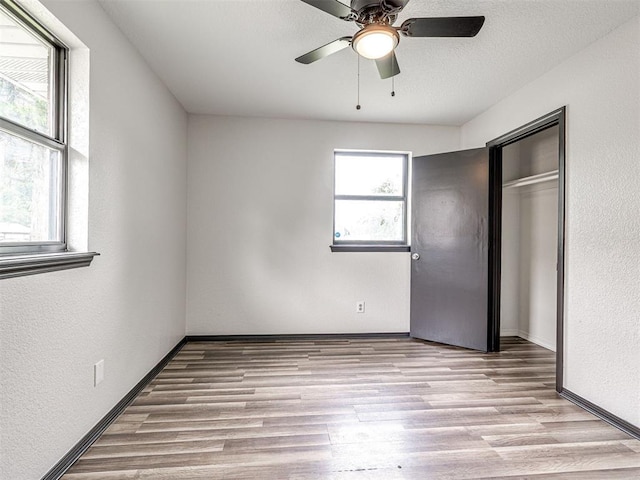 535 N Patchin Ave, Shawnee, OK 74801 - unfurnished bedroom with wood finished floors, ceiling fan, a textured wall, and a closet