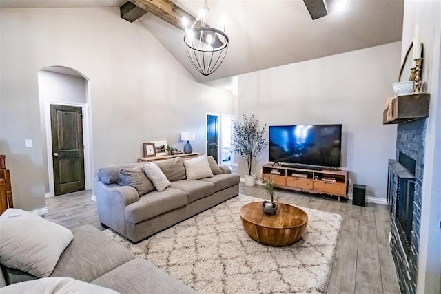 2713 Falling Leaves Dr, Weatherford, OK 73096 - living room featuring high vaulted ceiling, arched walkways, wood finished floors, beam ceiling, and a fireplace