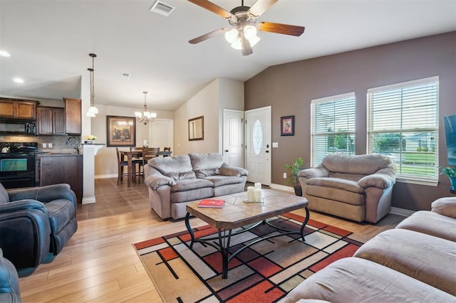1609 NW 144th Ter, Edmond, OK 73013 - living area featuring plenty of natural light, lofted ceiling, a chandelier, light wood-type flooring, and a ceiling fan
