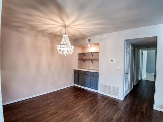 3003 River Oaks Dr Unit 119, Norman, OK 73072 - unfurnished dining area with dark wood finished floors and a chandelier