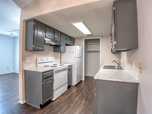3003 River Oaks Dr Unit 119, Norman, OK 73072 - kitchen featuring white appliances, under cabinet range hood, dark wood finished floors, gray cabinets, and a textured ceiling