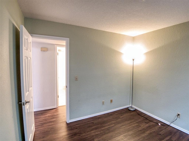3003 River Oaks Dr Unit 119, Norman, OK 73072 - spare room with dark wood-style flooring and a textured wall