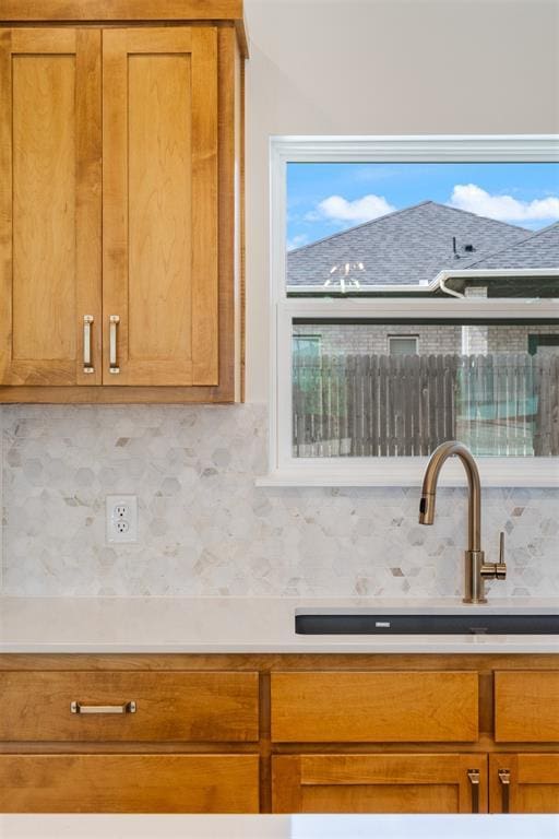 3825 NW 176th St, Edmond, OK 73012 - kitchen featuring tasteful backsplash, brown cabinetry, and light countertops
