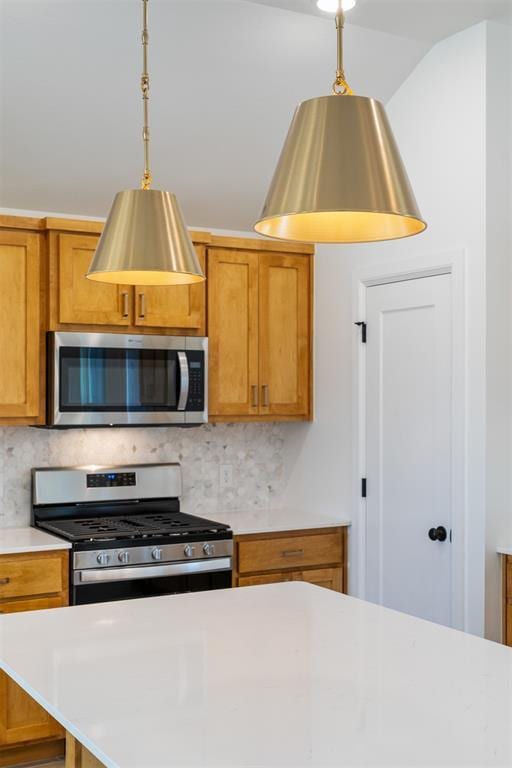 3825 NW 176th St, Edmond, OK 73012 - kitchen with appliances with stainless steel finishes, light countertops, decorative backsplash, brown cabinets, and pendant lighting