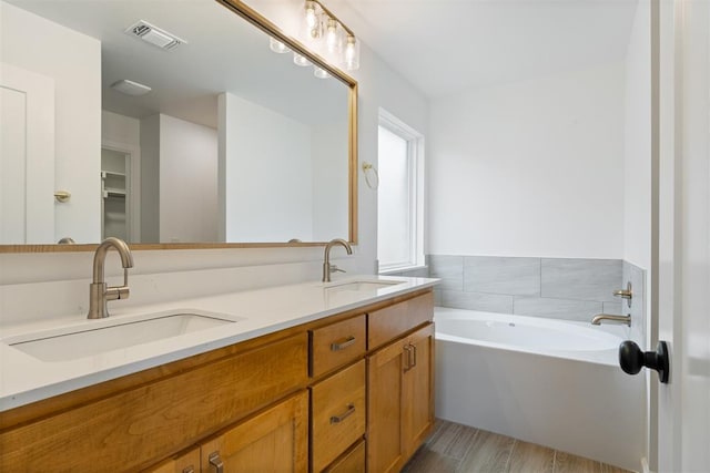 3825 NW 176th St, Edmond, OK 73012 - bathroom featuring double vanity, a garden tub, and wood finished floors