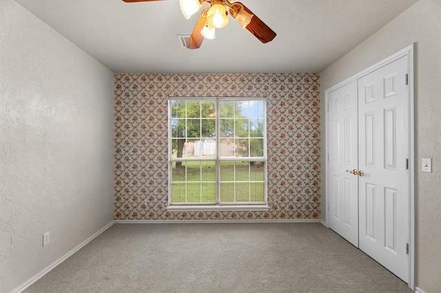 813 N Council Rd Unit S, Newcastle, OK 73065 - unfurnished bedroom with carpet flooring, wallpapered walls, a closet, and a ceiling fan