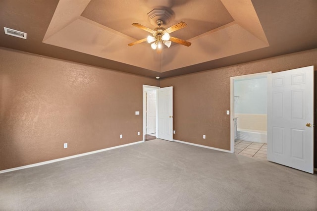 813 N Council Rd Unit S, Newcastle, OK 73065 - unfurnished bedroom featuring a raised ceiling, carpet floors, ensuite bath, and a ceiling fan