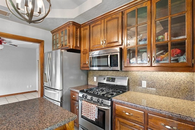 813 N Council Rd Unit S, Newcastle, OK 73065 - kitchen featuring stainless steel appliances, light tile patterned flooring, tasteful backsplash, brown cabinets, and a chandelier