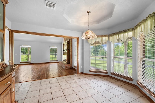 813 N Council Rd Unit S, Newcastle, OK 73065 - unfurnished dining area with a chandelier, a tray ceiling, and light tile patterned floors