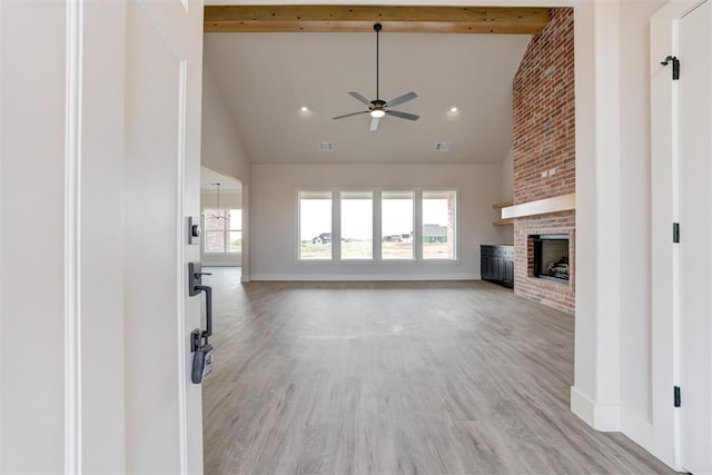 4163 Hawthorne St, Piedmont, OK 73078 - unfurnished living room featuring ceiling fan, high vaulted ceiling, a brick fireplace, light wood-style floors, and beamed ceiling