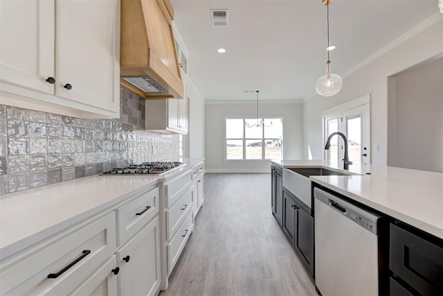 4163 Hawthorne St, Piedmont, OK 73078 - kitchen with stainless steel appliances, premium range hood, light countertops, crown molding, and hanging light fixtures